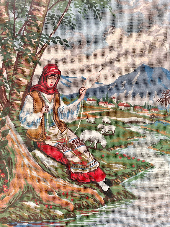 Broderie ancienne encadrée – Bergère filant la laine au bord d’une rivière