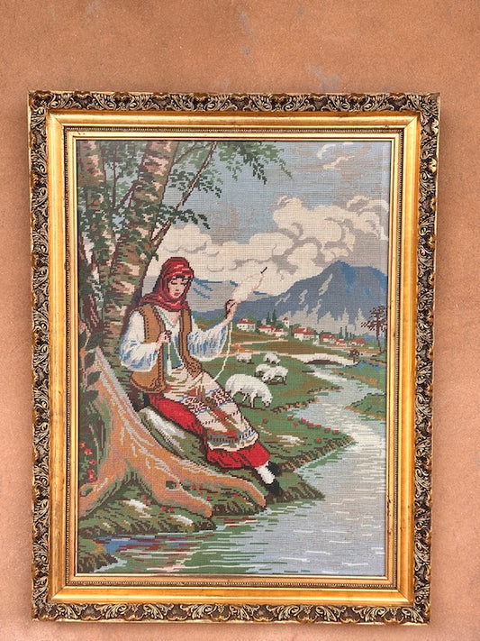 Broderie ancienne encadrée – Bergère filant la laine au bord d’une rivière